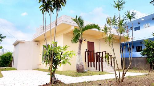 a house with palm trees in front of it at NEWOPEN Villa lanikai in Kabira