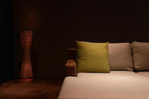 a couch with a pillow and a vase in a room at NEWOPEN Villa lanikai in Kabira