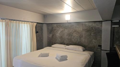 a bedroom with a bed with two towels on it at Classic home in Bang Tao Beach
