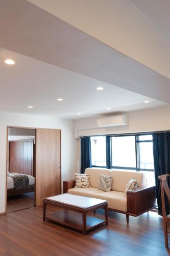 a living room with a couch and a bed at Nihonbashi Royal in Osaka