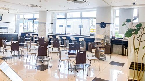 a dining room with chairs and tables and windows at Toyoko Inn Banshu Ako Ekimae in Ako