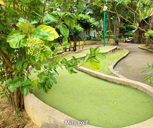 a garden with green grass next to a road at Costa Mahkota Stylish 2-Bedroom Pool View 1 Queen & 2 Singles in Melaka