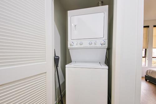 a washer and dryer in a kitchen next to a door at The Carlton - Modern-Lux 2 Master Suites-Secure Bldg & Parking- 5 BLKS to Ocean Ave in Los Angeles