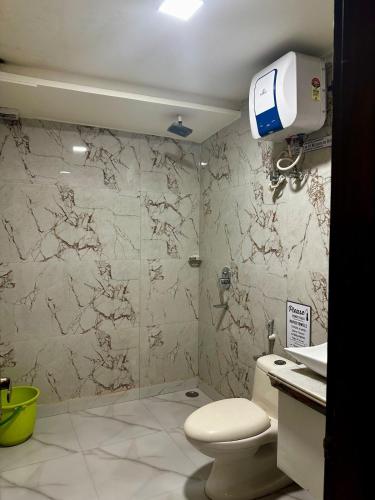 a bathroom with a toilet and a glass shower at Taj Castle Homestay sutable for 17 Peoples in Agra