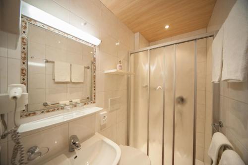łazienka z prysznicem, toaletą i umywalką w obiekcie Hotel Garni Waldhof - Wohlfühlen am Lech w mieście Stanzach