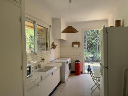 une cuisine blanche avec un évier et une fenêtre dans l'établissement Villa avec piscine privée, proche plage - FR-1-100-345, à La Croix-Valmer