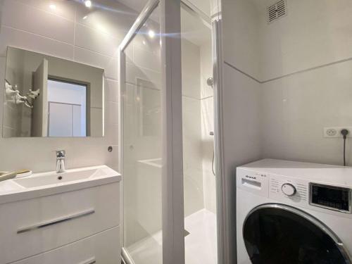 une salle de bain avec une machine à laver et un lavabo dans l'établissement Appartement 4 pièces/6 couchages proche plage - LE POULIGUEN - FR-1-245-210, au Pouliguen