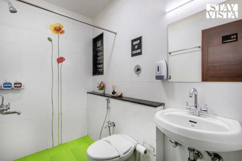 Un baño blanco con lavabo e inodoro. en Serenity Meadows with Pool by VEO - Part of StayVista, en Nashik
