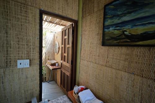 a hallway with a door and a painting on the wall at Hành Ngò Homestay - Hòn Đỏ Ninh Thuận in Thôn Dư Khánh