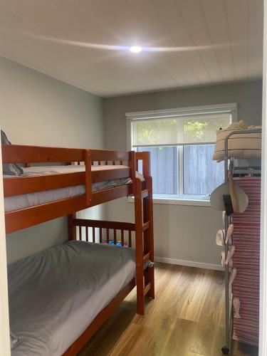 a bedroom with two bunk beds and a window at Beach Buoy Opossum Bay in South Arm