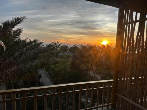a sunset from the balcony of a house at Hành Ngò Homestay - Hòn Đỏ Ninh Thuận in Thôn Dư Khánh