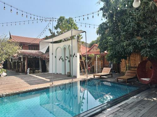 a swimming pool with a gazebo next to a house at Montri Resort Donmuang Bangkok in Bangkok