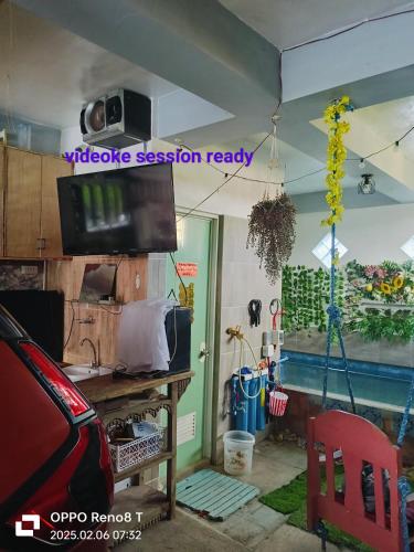 a living room with a tv on the wall and a table at Modern Loft House Ormoc in Ormoc