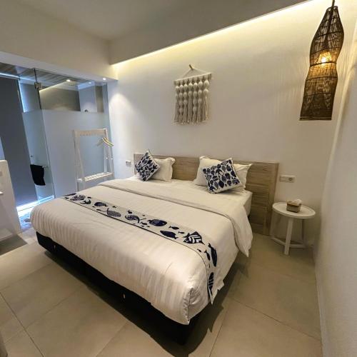 a bedroom with a large bed with blue and white pillows at Little Mykonos in Bandung