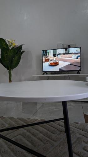 モンバサにあるElegant Studio in Bamburi Fisheriesの白いコーヒーテーブル(壁にテレビ付)