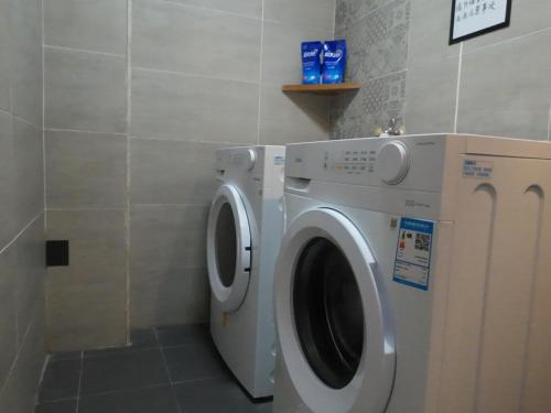 a washer and dryer in a bathroom with a wall at Autumn Inn in Yangshuo