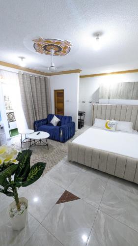 モンバサにあるElegant Studio in Bamburi Fisheriesのベッドと青いソファのある寝室