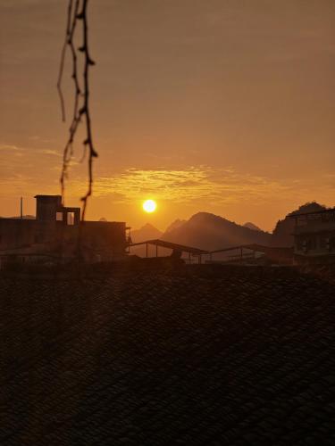 a sunset with the sun setting in the distance at Autumn Inn in Yangshuo