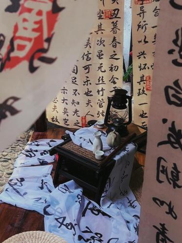 a room with a table with writing on the wall at Autumn Inn in Yangshuo