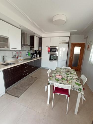 a kitchen with a table and chairs and a kitchen with white cabinets at Merci Beach House in Carvoeira