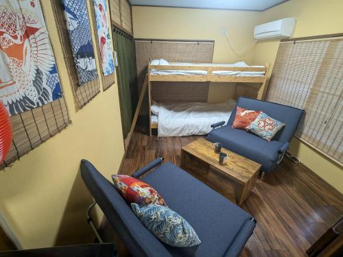 a room with two chairs and a bunk bed at Matsuri House 20min to Ueno in Tokyo