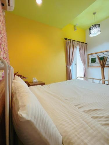 a bedroom with a large white bed with a window at 17 Happiness in Xiaoliuqiu