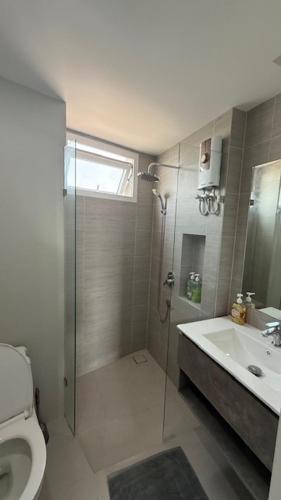 a bathroom with a shower and a toilet and a sink at BEACH Condo Mae Phim in Ban Tha Fat
