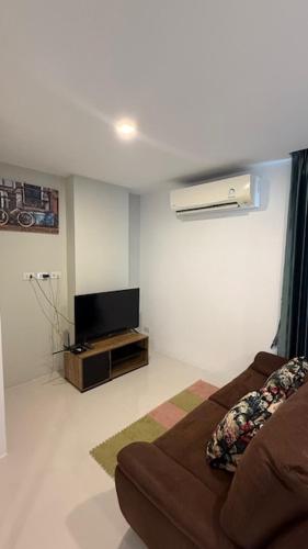 a living room with a couch and a television at BEACH Condo Mae Phim in Ban Tha Fat