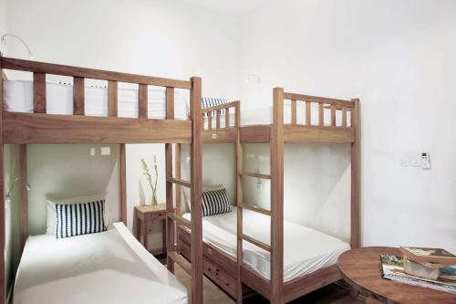 two bunk beds in a room with a table at Adhisthana Hotel Yogyakarta in Yogyakarta