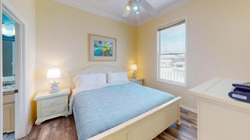 a bedroom with a bed and two night stands and a window at Sea Watch-Beachfront-Private Pool-Pet Friendly in St. George Island