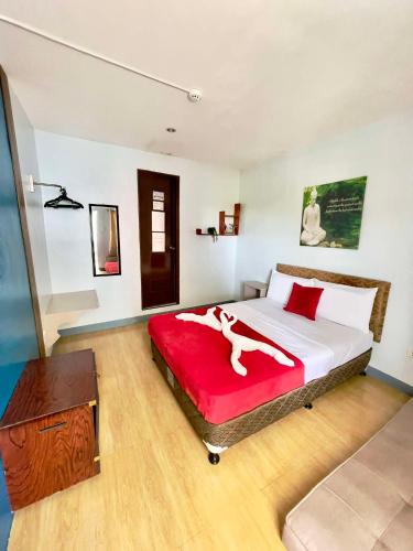 a bedroom with a large bed with a red blanket at Little Rock Cebu in Mactan