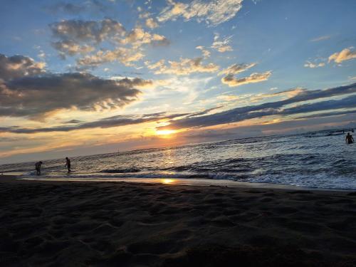 people walking on the beach at sunset at RÊV BOR D'MER in Étang-Salé les Bains