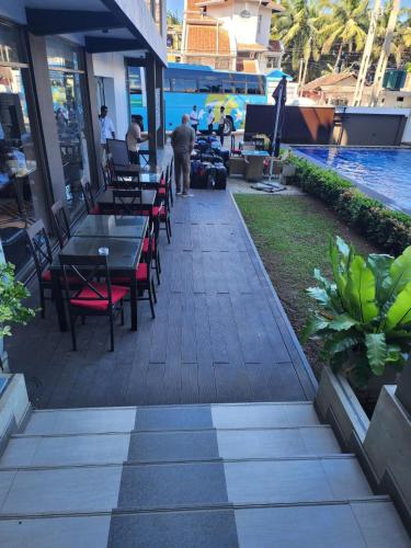 a patio with tables and chairs next to a pool at Ruvisha Beach Hotel in Negombo