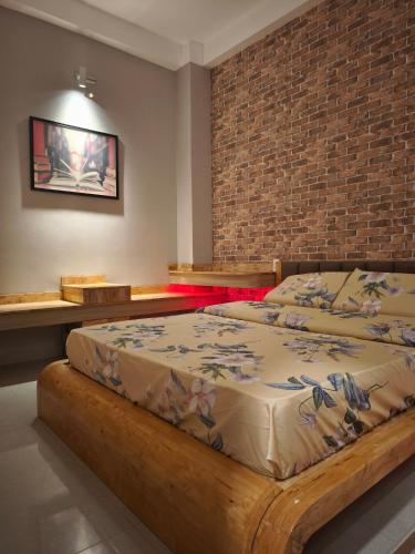 a bedroom with a large bed in a brick wall at Long Homestay Xuyên Á - Hotels in Ðức Hòa