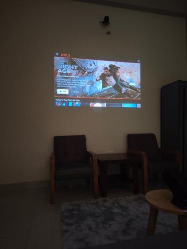 a projection screen on the wall of a living room at Long Homestay Xuyên Á - Hotels in Ðức Hòa