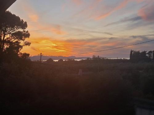 a sunset view from the window of a house at Olga's Garden Apartments in Almiros Beach