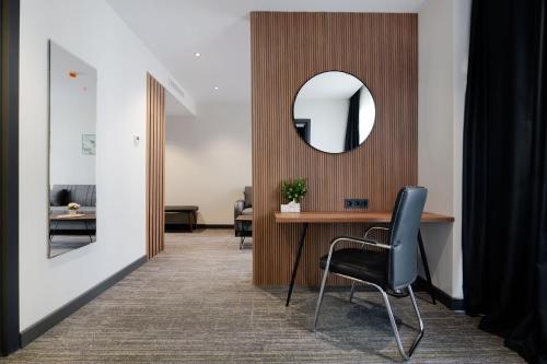 a room with a table and a mirror and a chair at NOVA LUXE Hotel & Residences in Batumi