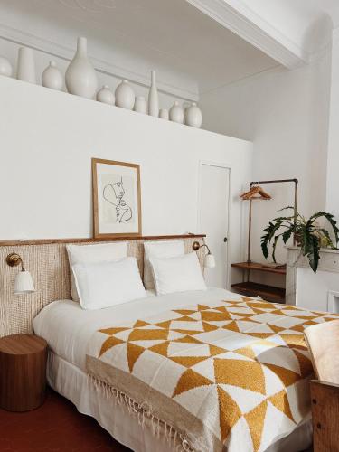 - une chambre avec un grand lit aux murs blancs dans l'établissement Maison Acacia - La bibliothèque, à La Ciotat