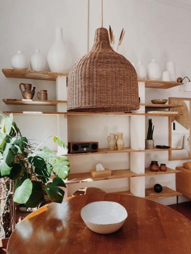 une salle à manger avec une table en bois et un panier dans l'établissement Maison Acacia - La bibliothèque, à La Ciotat