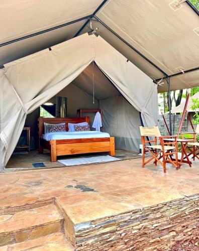 a tent with a bed and a chair in it at Kivulini Eco Park Karen in Nairobi