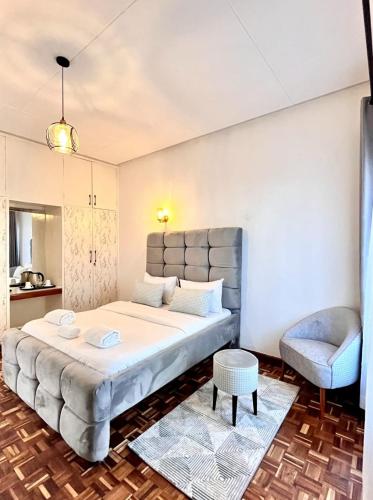 a bedroom with a large bed and a chair at Kivulini Eco Park Karen in Nairobi