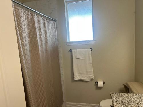 a bathroom with a shower curtain and a window at Chic 1BHK Haven Quiet & Relaxing Near Austin in Cedar Park