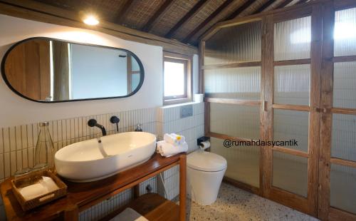 Un baño con lavabo, inodoro y espejo. en Poolside Villa With Monkey View in Kaba-Kaba, en Tumbak Bayuh