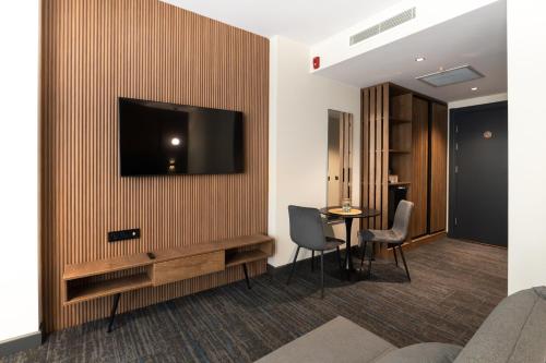 a room with a tv on a wall with a table at NOVA LUXE Hotel & Residences in Batumi