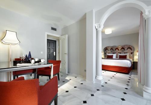 a bedroom with a bed and a table and chairs at Eurostars Conquistador in Córdoba