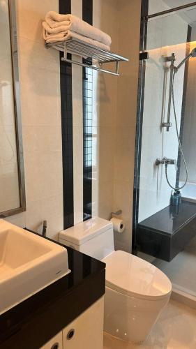 a bathroom with a white toilet and a sink at Spacious Sukhumvit Condo near EmQuartier in Bangkok