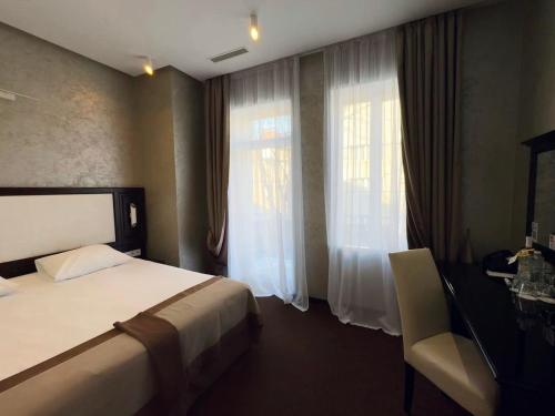a hotel room with a bed and a window at Optima Collection Khmelnytskyi in Khmelʼnytsʼkyy