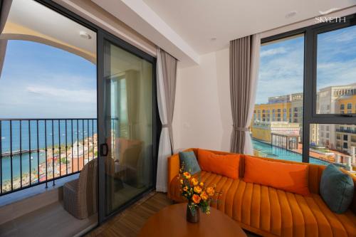 a living room with a couch and a balcony at Luna Sol Villas - Dedicated Care Until Check Out in Phu Quoc