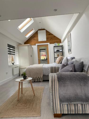 a living room with a couch and a table at Seatribe Cabin, Cozy snug by the Sea in South Hayling