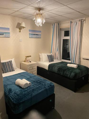 a bedroom with two beds and a chandelier at The Lane Head Hotel in Brighouse